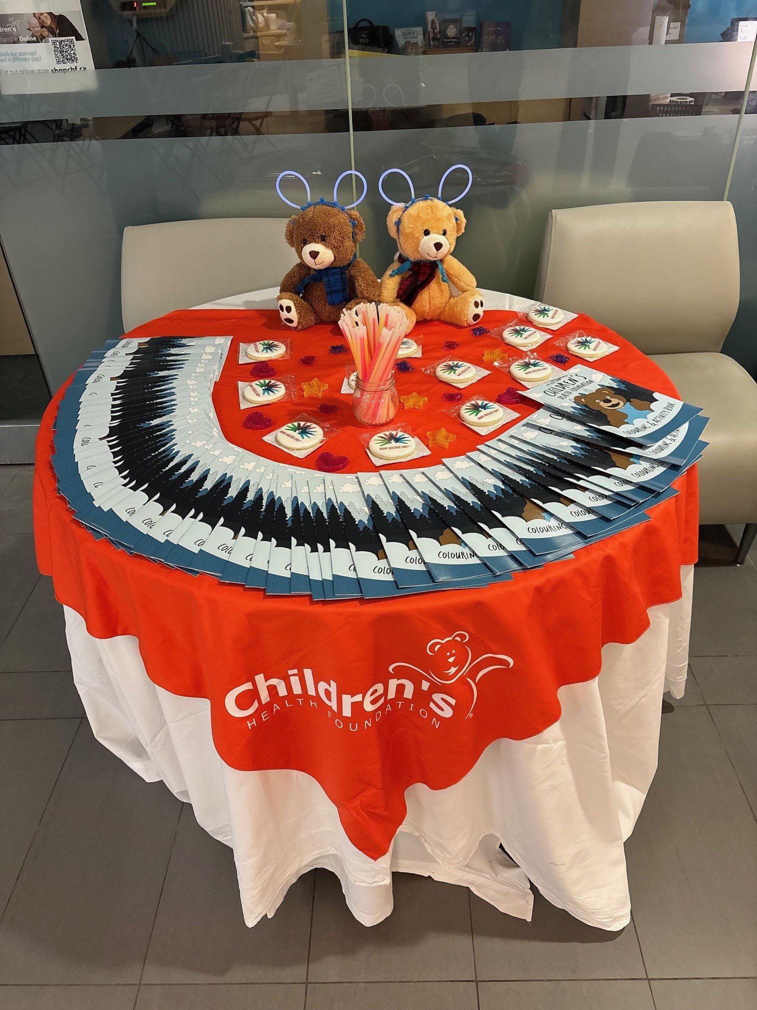 Table of colouring and activity books, glowsticks, cookies, and two teddy bears at London Health Sciences Centre. Photo courtesy of Cara Grobbecker.